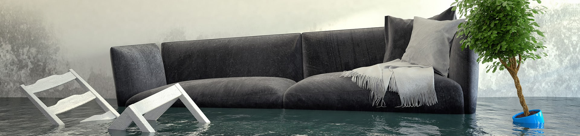 A home flooded with water with a plant, chair and couch floating on the water due to a sump pump break