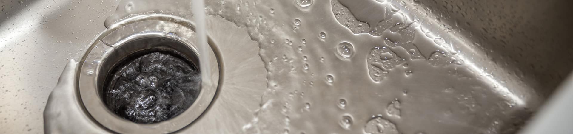 Water running on a newly installed garbage disposal in a kitchen sink