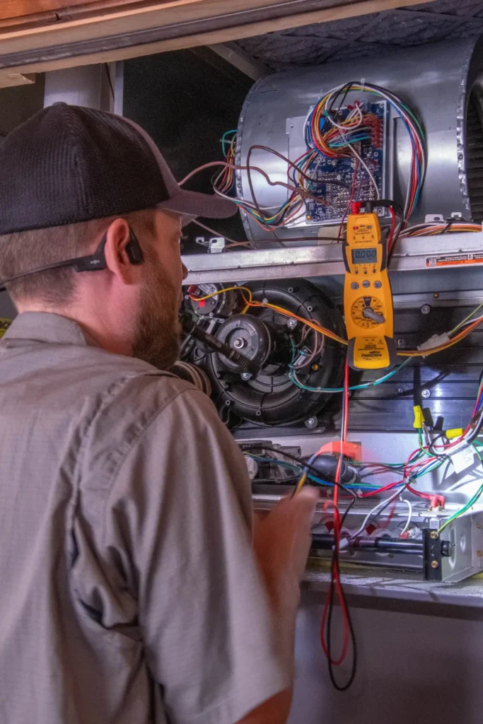 Technician repairing HVAC system with diagnostic tools