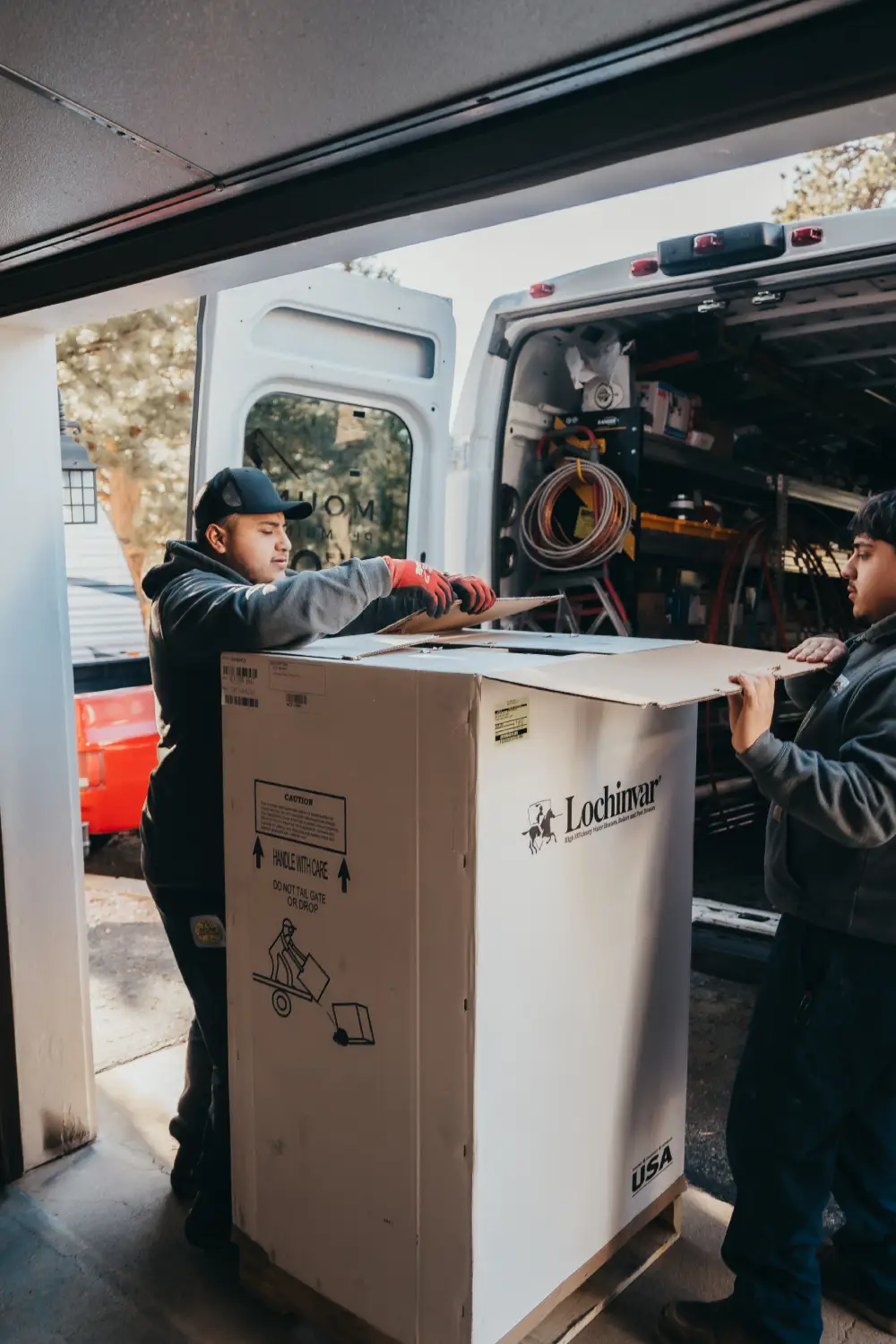 Workers loading equipment into a van for transportation